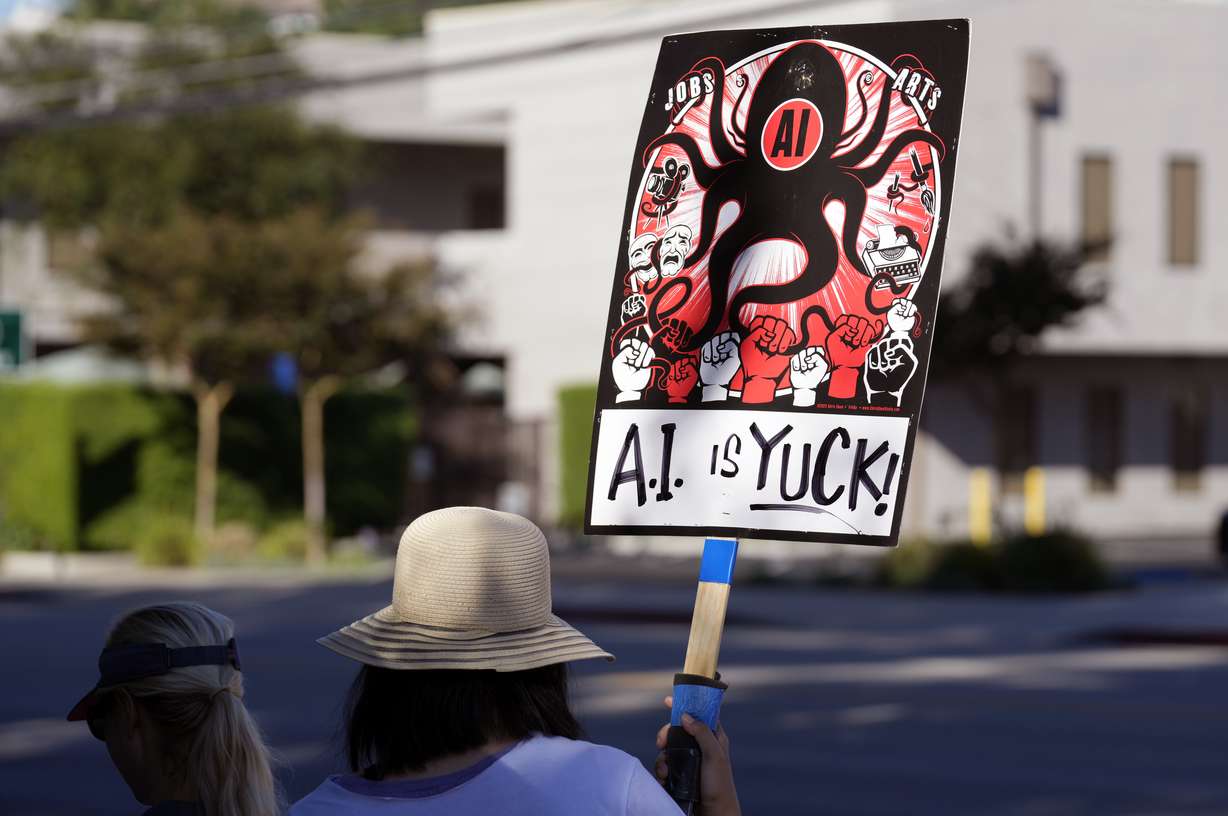 A striking SAG-AFTRA member holds up a sign in a picket line outside Walt Disney Studios, Oct. 20, in Burbank, Calif. Saturday marks the 100th day of the SAG-AFTRA strike, which is now the longest of the union's history.