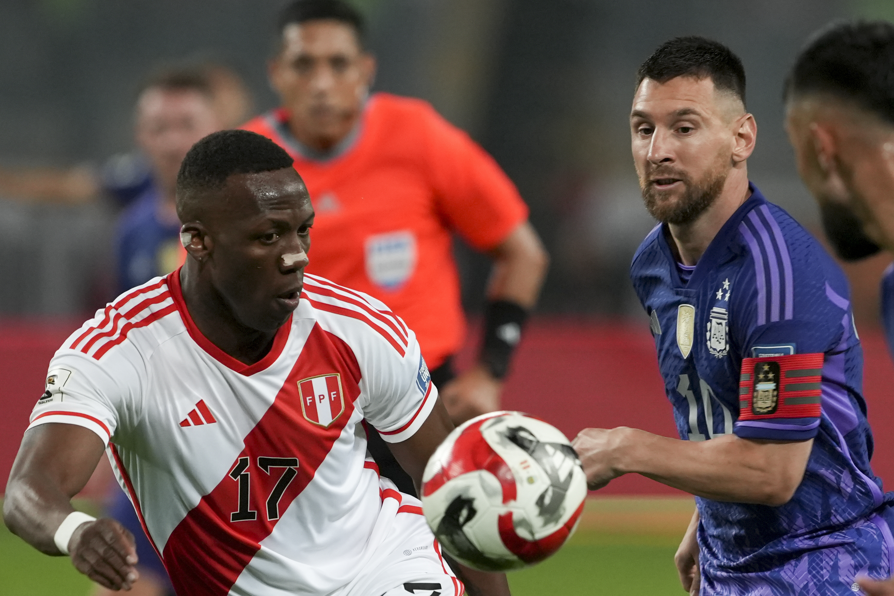 Peru's Luis Advincula, left, and Argentina's Lionel Messi battle for the ball during a qualifying soccer match for the FIFA World Cup 2026 at the National stadium in Lima, Peru, Tuesday, Oct. 17, 2023.