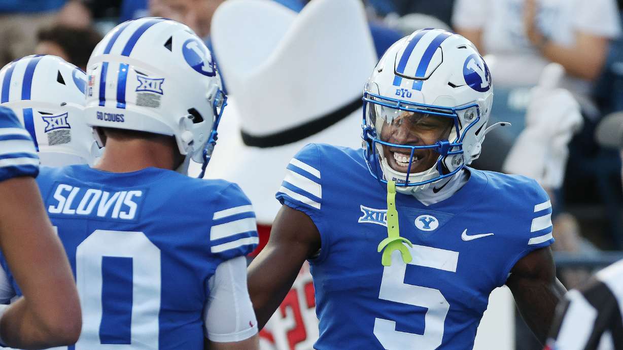 Brigham Young wide receiver Darius Lassiter (5) celebrates his touchdown with Brigham Young quarterback Kedon Slovis (10) in Provo on Saturday, Oct. 21, 2023.