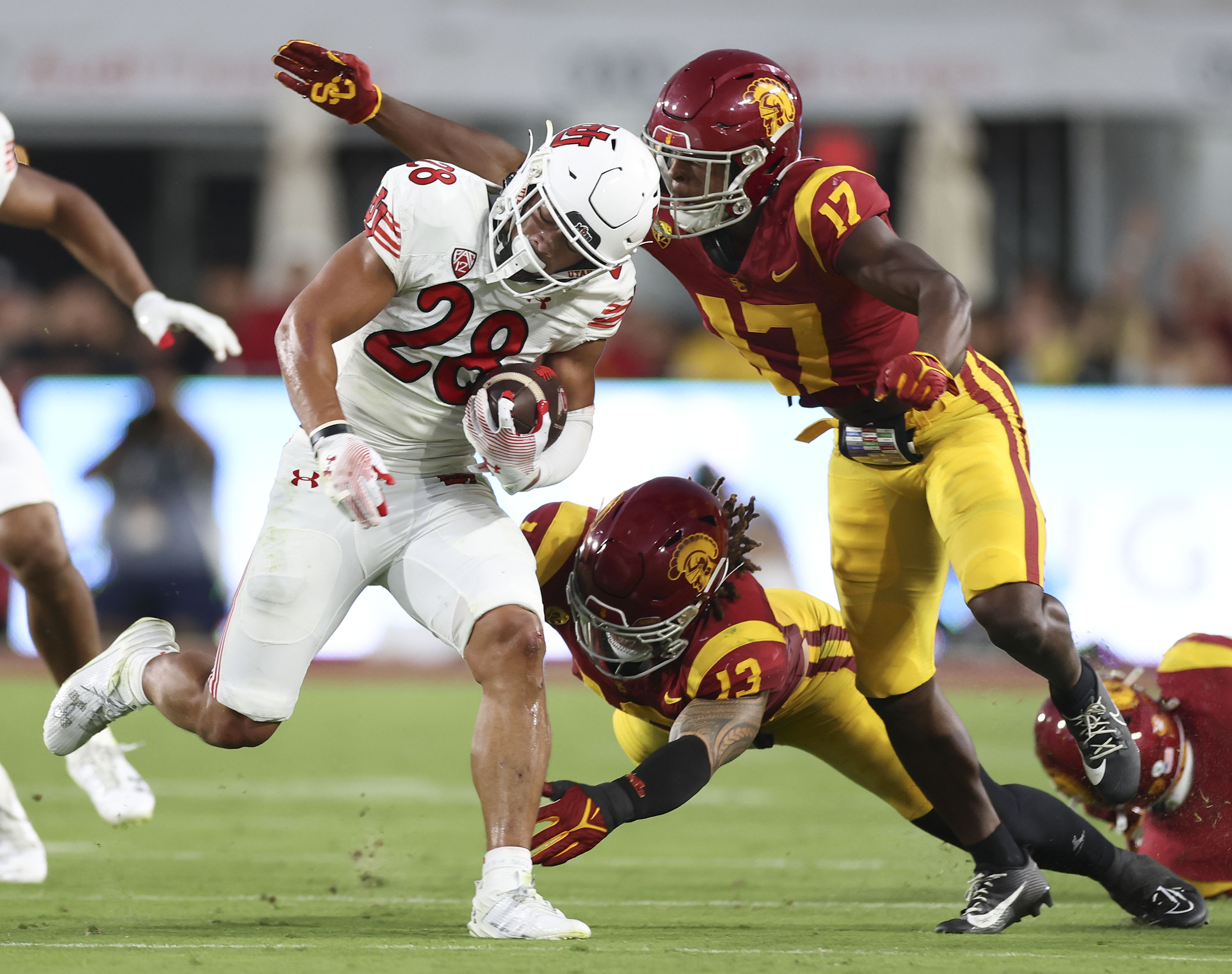 Utah Utes safety Sione Vaki (28) runs against USC Trojans cornerback Christian Roland-Wallace (17) and linebacker Mason Cobb (13) at the Los Angeles Memorial Coliseum on Saturday, Oct. 21, 2023.