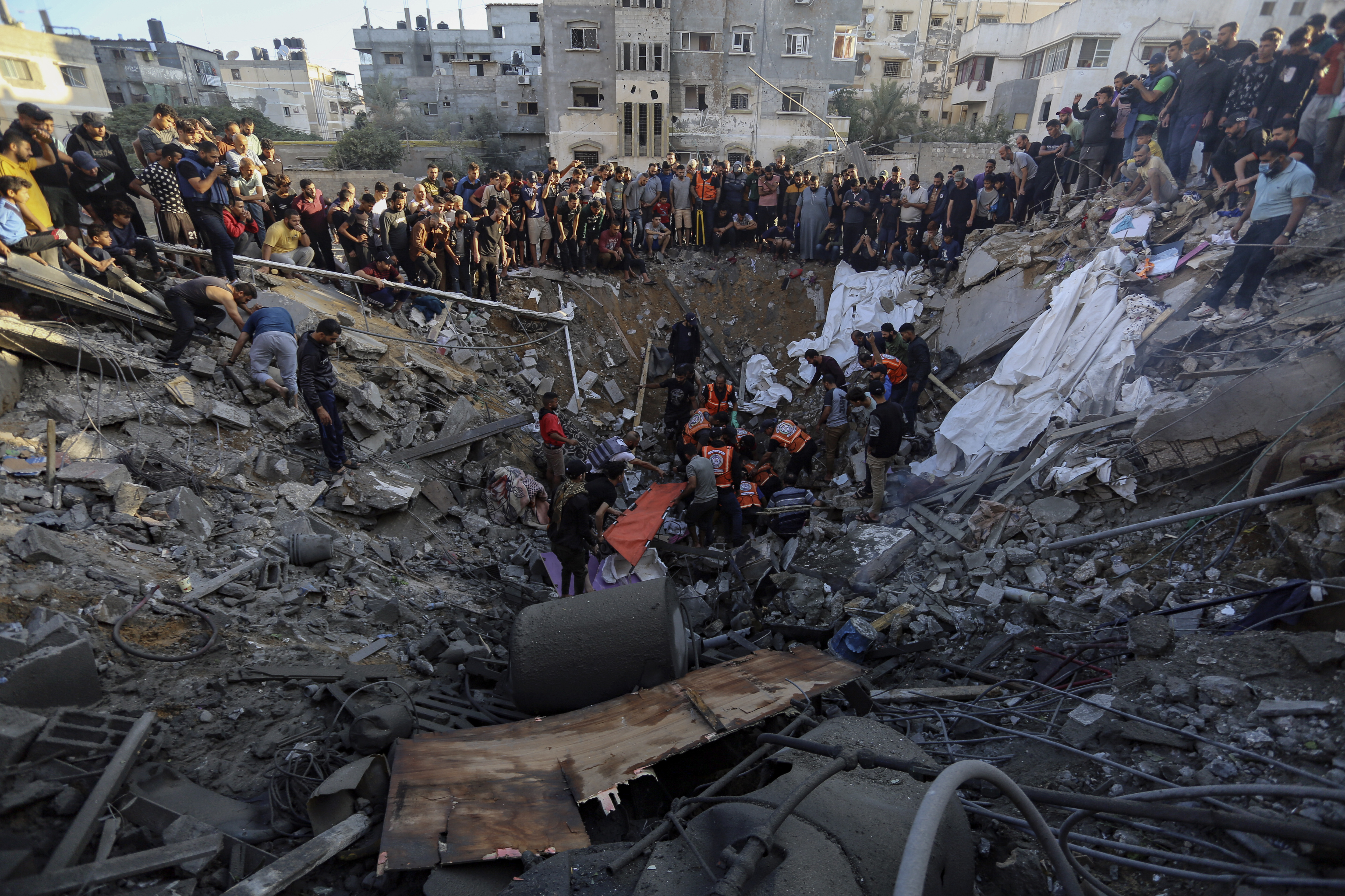 Palestinians gather over the remains of a destroyed house following Israeli airstrikes on Gaza City, Saturday.