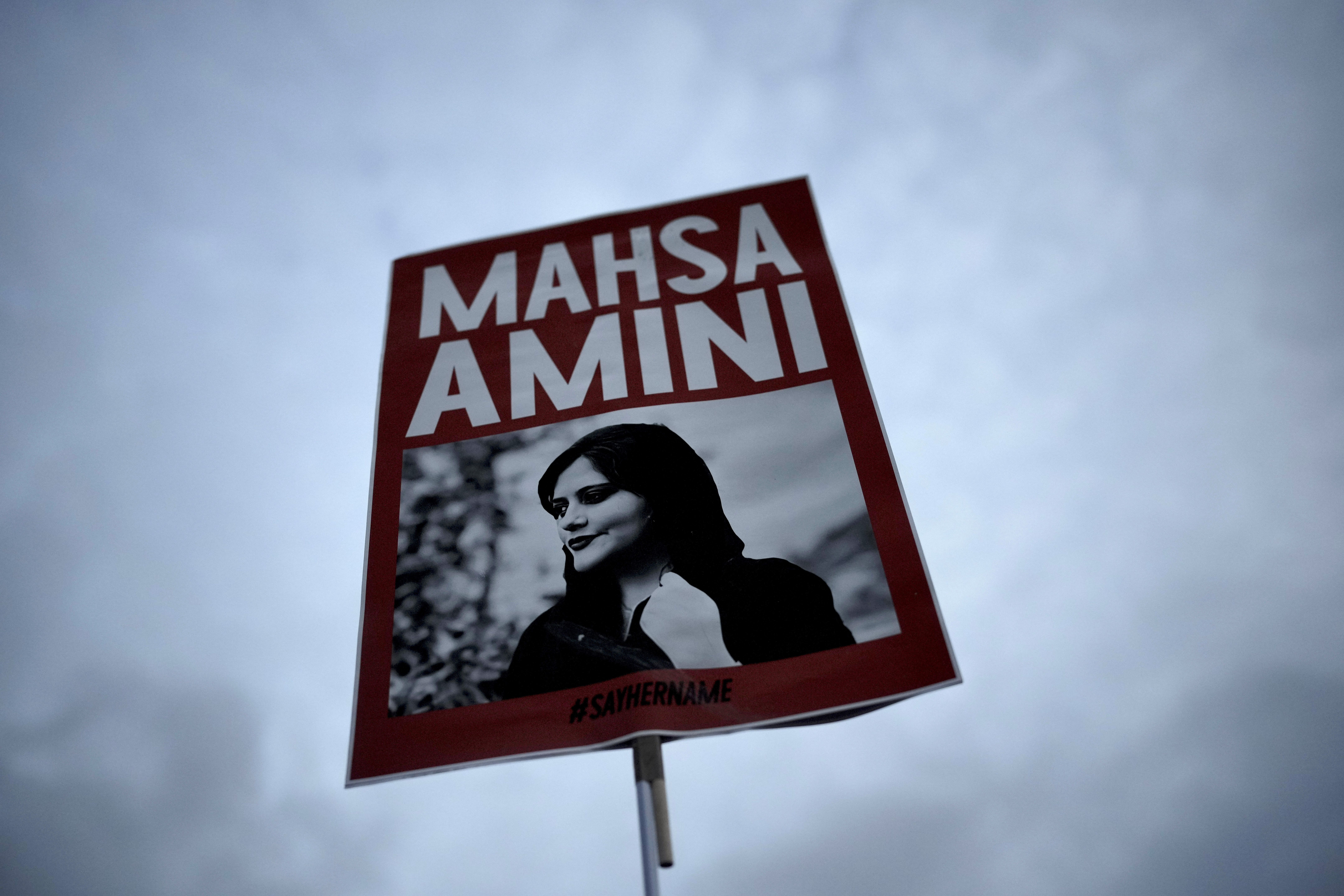 A woman holds a picture of Iranian woman Mahsa Amini during a protest against her death, in Berlin, Germany, on Sept. 28, 2022. A court in Iran sentenced two female journalists to up to seven years in prison for “collaborating” with the United States.