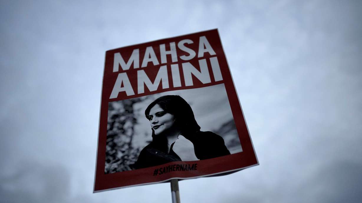 A woman holds a picture of Iranian woman Mahsa Amini during a protest against her death, in Berlin, Germany, on Sept. 28, 2022. A court in Iran sentenced two female journalists to up to seven years in prison for “collaborating” with the United States.