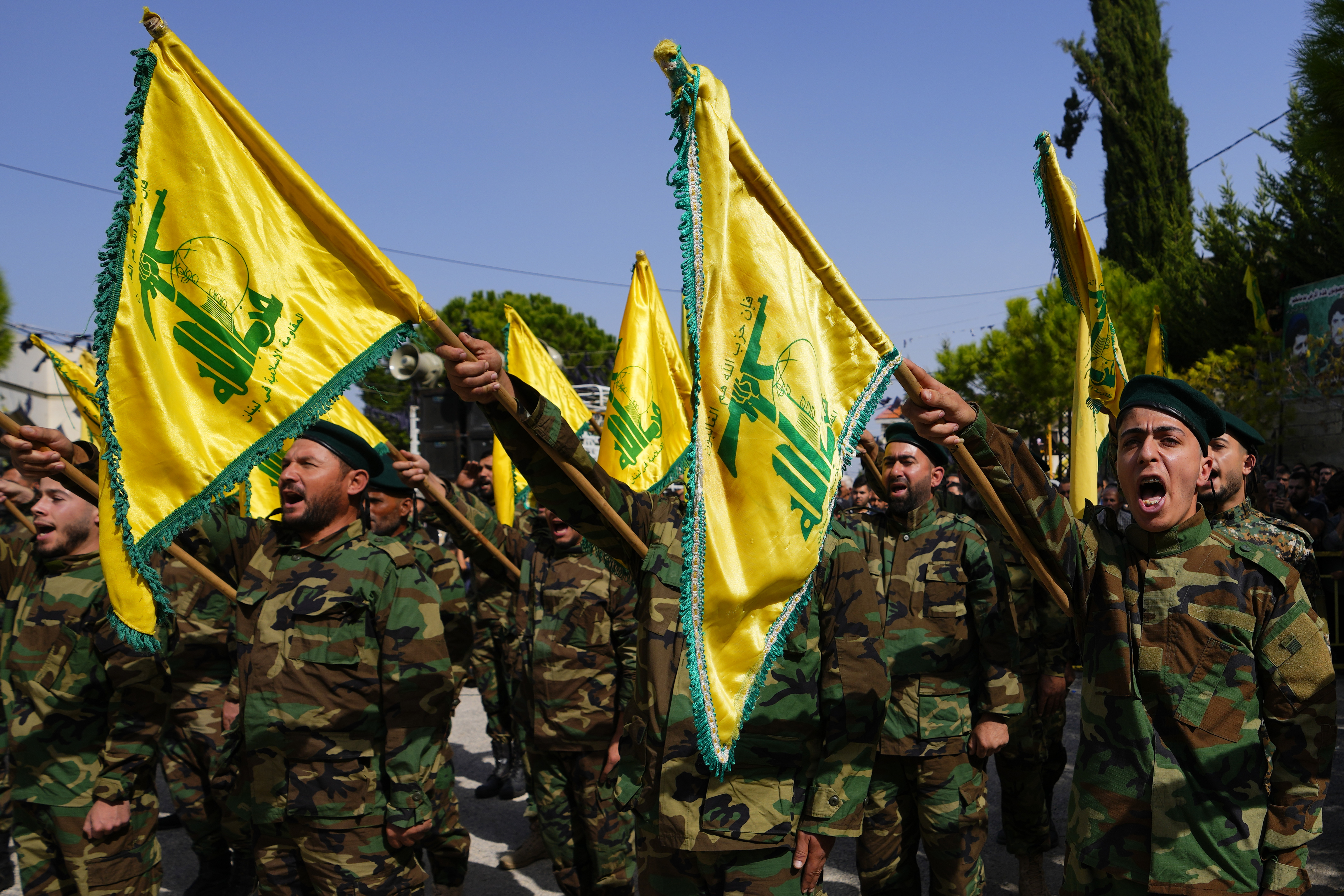 Hezbollah fighters rise their group's flag and shout slogans, as they attend the funeral procession of Hezbollah fighter, Bilal Nemr Rmeiti, who was killed by Israeli shelling, during his funeral procession in Majadel village, south Lebanon, Sunday.