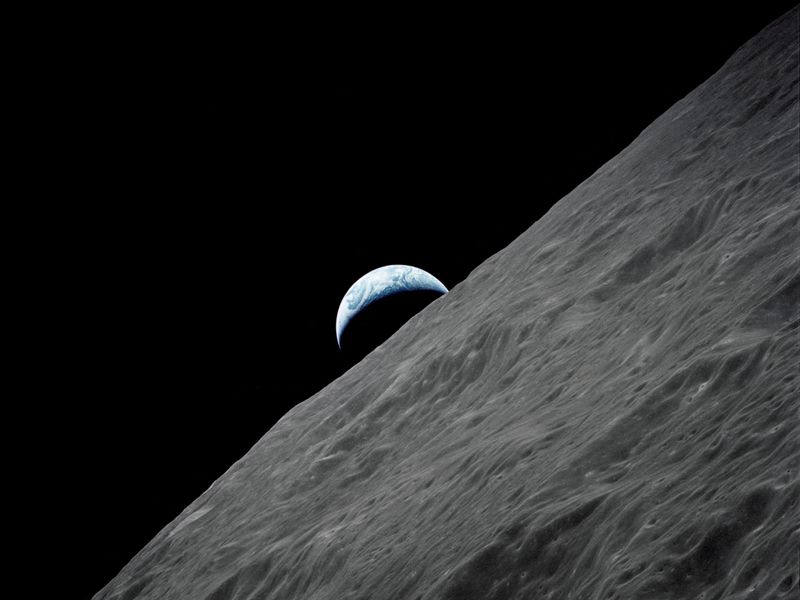 The crescent Earth rises above the lunar horizon in this photo taken from the Apollo 17 spacecraft in lunar orbit in 1972. Soil and rock samples collected then have revealed the moon's age.