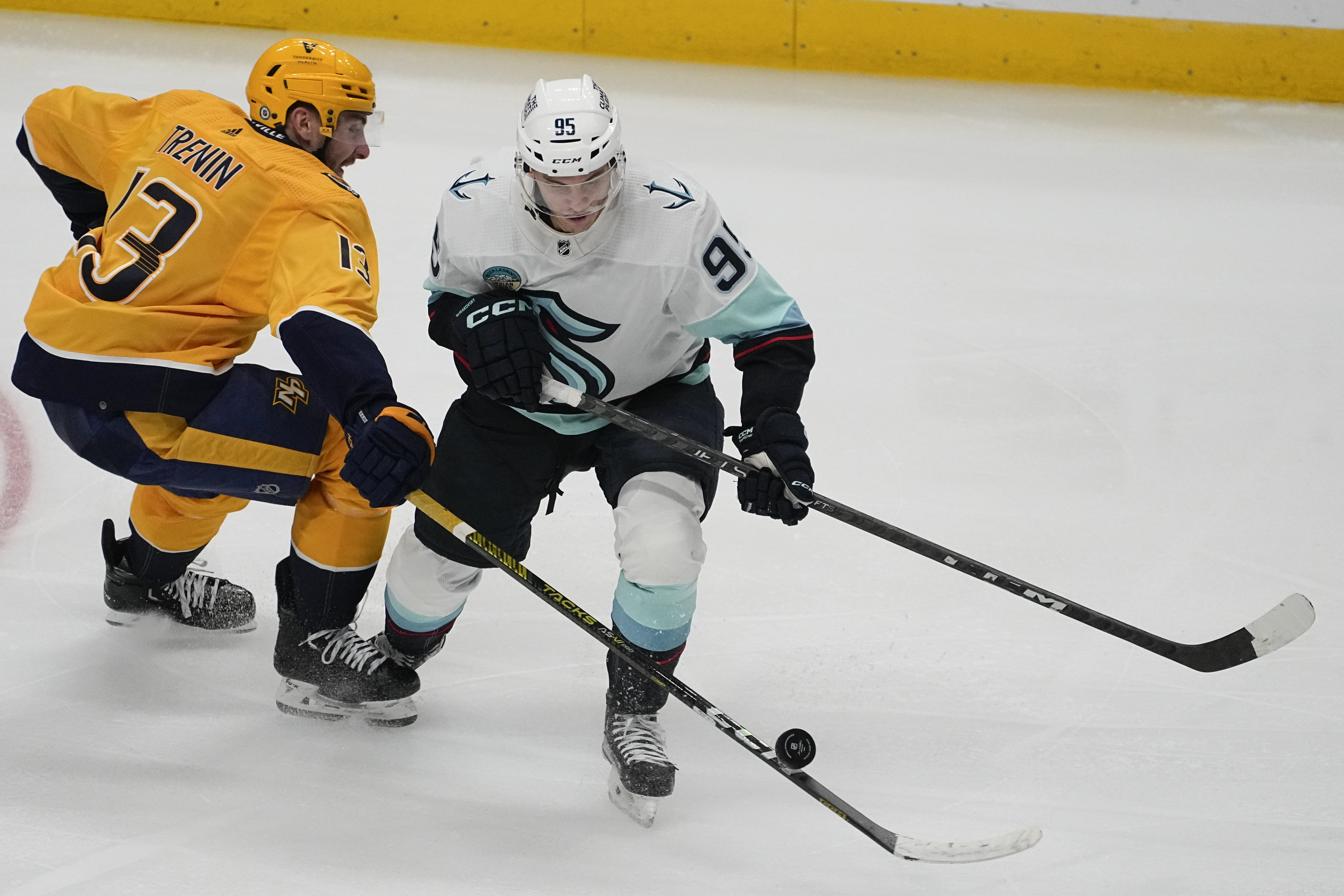 Nashville Predators center Yakov Trenin, left, takes the puck from Seattle Kraken left wing Andre Burakovsky (95) during the third period of an NHL hockey game Thursday, Oct. 12, 2023, in Nashville, Tenn. The Predators won 3-0. 