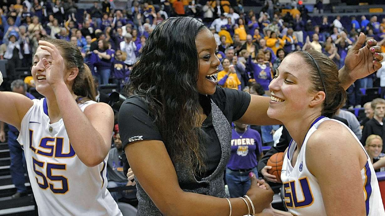 FILE - LSU's Theresa Plaisance (55) walks past then-LSU assistant coach Tasha Butts as she celebrates the team's win over Kentucky with guard Jeanne Kenney after an NCAA college basketball game in Baton Rouge, La., Feb. 24, 2013. Georgetown women's basketball coach Tasha Butts died Monday, Oct. 23, 2023, after a two-year battle with breast cancer. The 41-year-old coach was diagnosed with advanced stage breast cancer in 2021. She stepped away from coaching Georgetown last month.