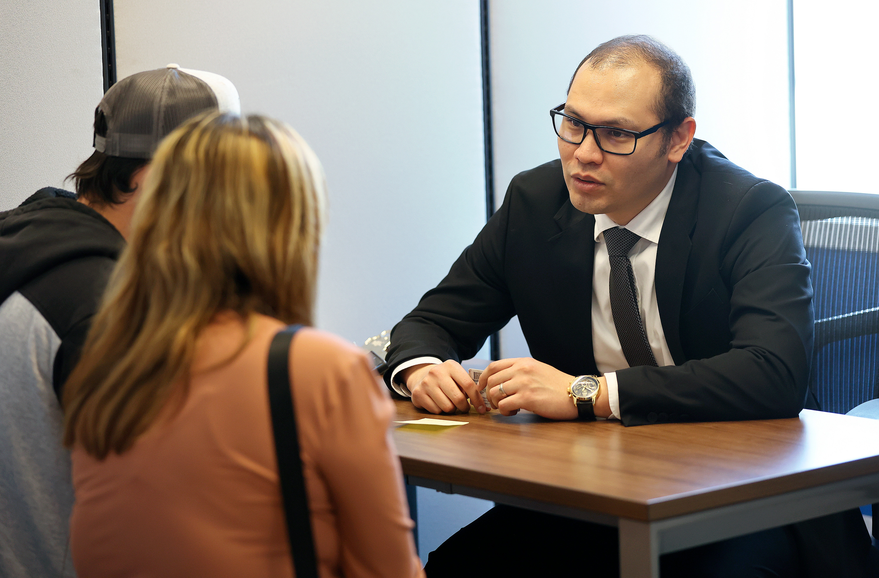 Fernando Perez, El Salvador consul general, talks with Jose Aviles, left, at the consulate in Salt Lake City on March 21. The consulate is urging El Salvadorans to renew their documents ahead of the country's 2024 elections.