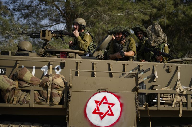 Israeli soldiers drive an armored personnel carrier near the border with the Gaza Strip, in southern Israel, Sunday.