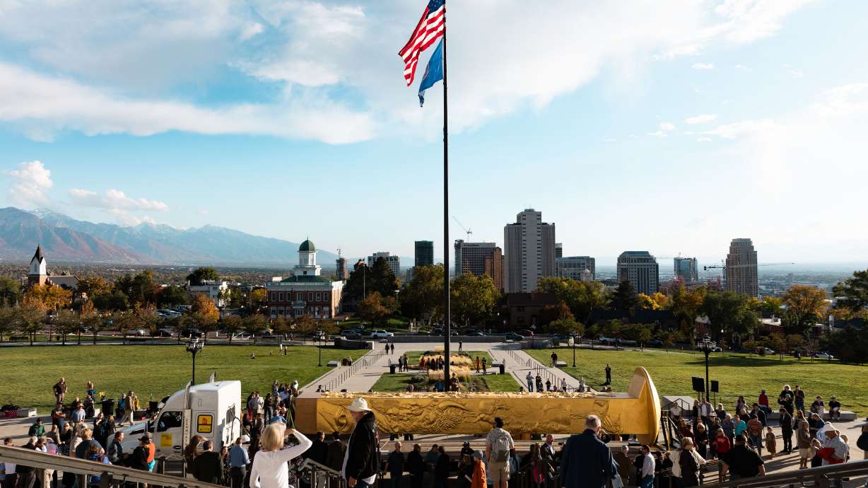 Attendees step up to see the Golden Spike Monument after its arrival at the state Capitol on Oct. 23, 2023. The piece will be housed at This Is The Place Heritage Park in Salt Lake City, the Golden Spike Foundation announced Friday.