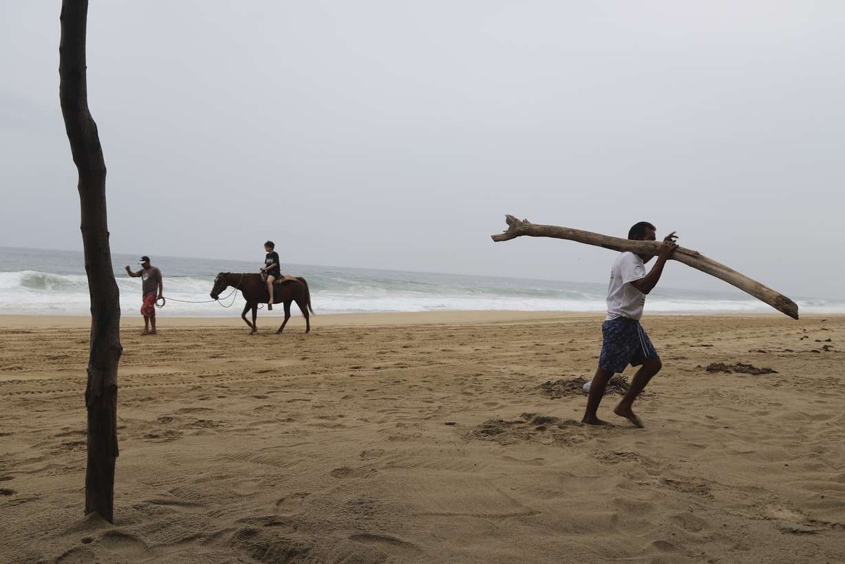 A tourist rides a horse at a beach in Acapulco, Mexico, Tuesday. Hurricane Otis slammed into Mexico's southern Pacific coast as a catastrophic Category 5 hurricane early Wednesday.