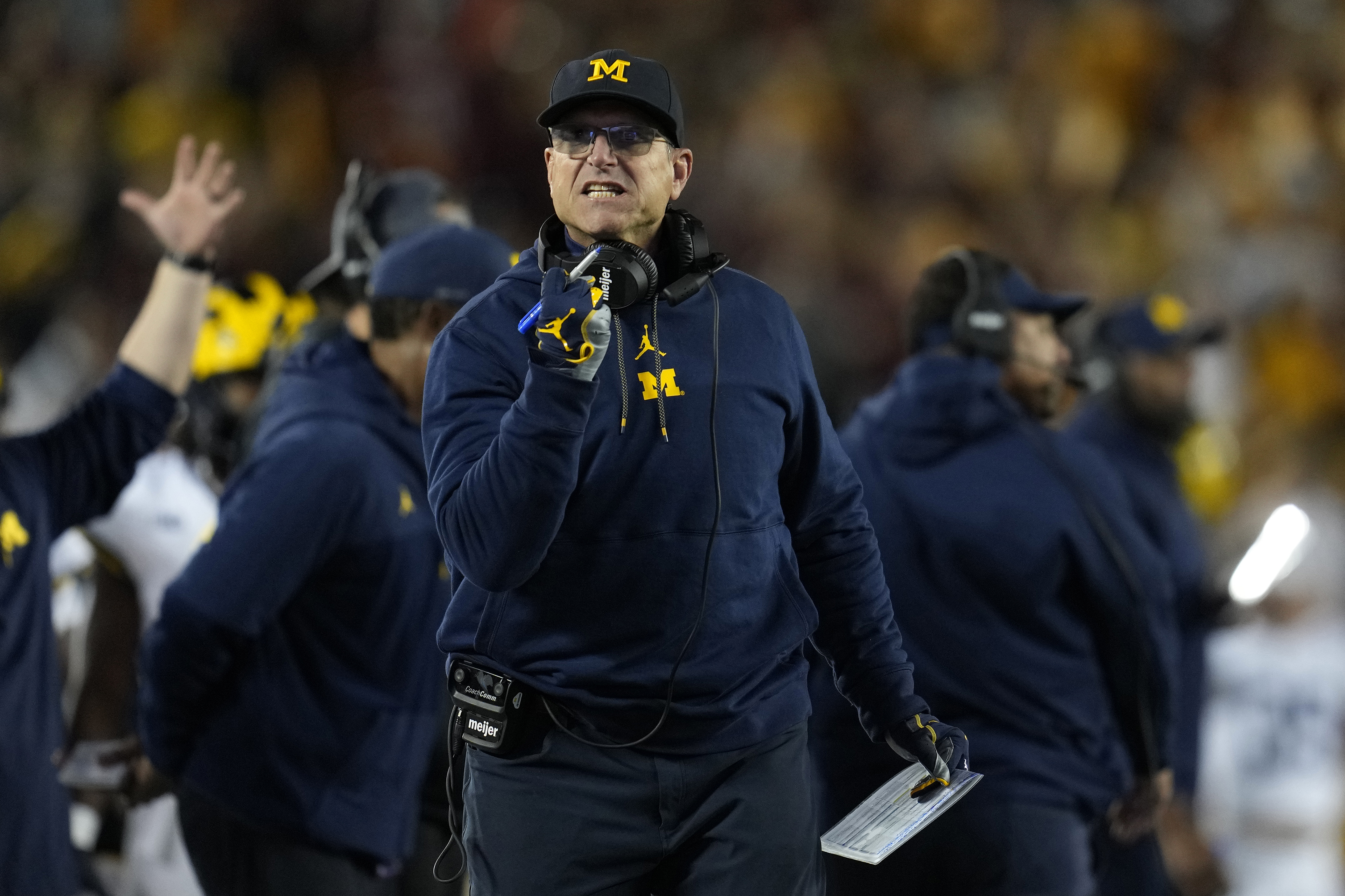 FILE - Michigan head coach Jim Harbaugh gestures toward a referee during the first half of an NCAA college football game against Minnesota Saturday, Oct. 7, 2023, in Minneapolis. The NCAA banned in-person advanced scouting in 1994 in part because not every school could afford to do it. Now Michigan is being investigated by the NCAA for a sign-stealing scheme that allegedly involved people secretly being sent to record opponents’ games. No. 2 Michigan and the Big Ten acknowledged the investigation Thursday, Oct. 19, 2023.