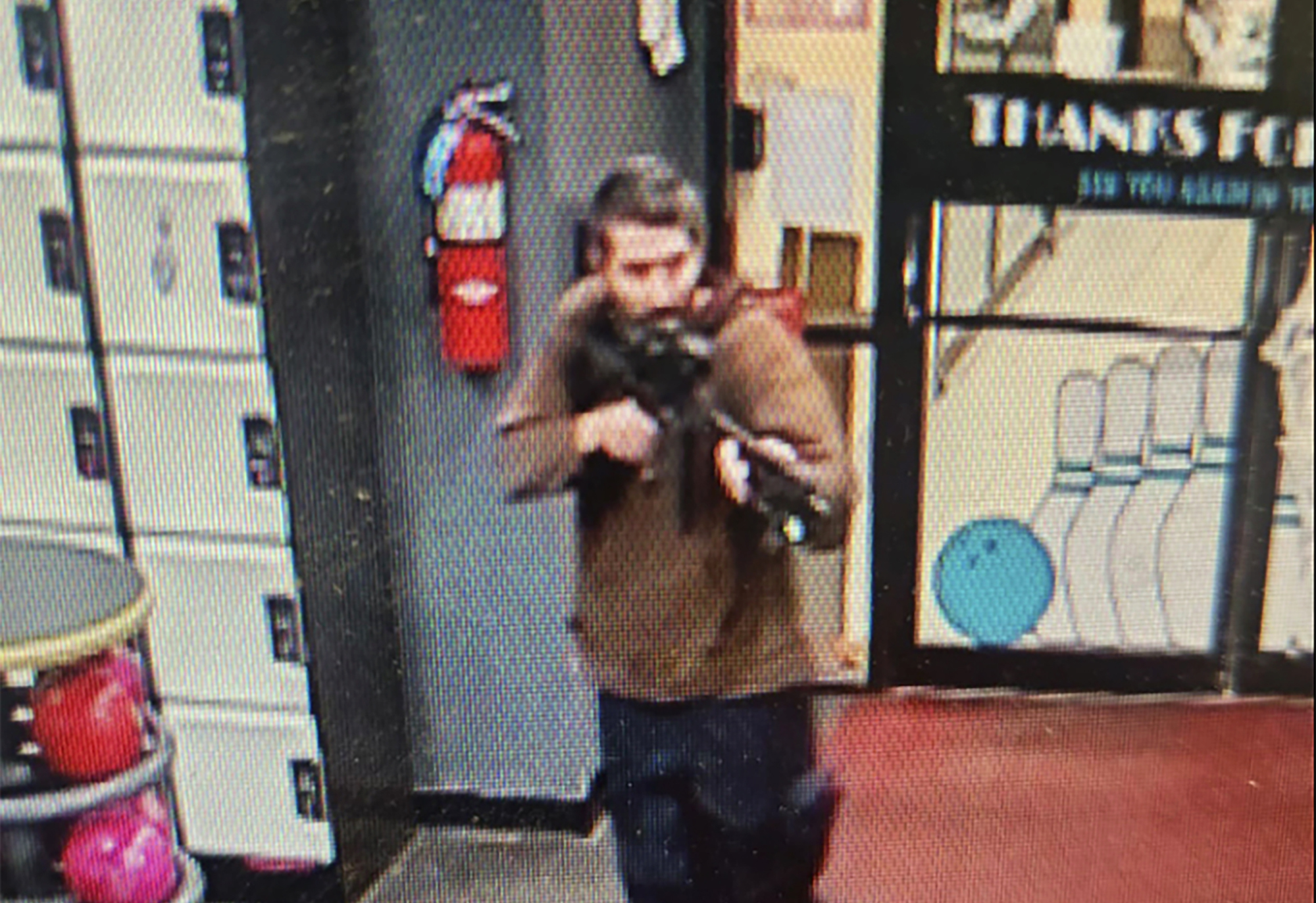 An unidentified shooter points a gun while entering Sparetime Recreation in Lewiston, Maine, on Wednesday. Maine State Police ordered residents in the state's second-largest city to shelter in place Wednesday night as the suspect remains at large.