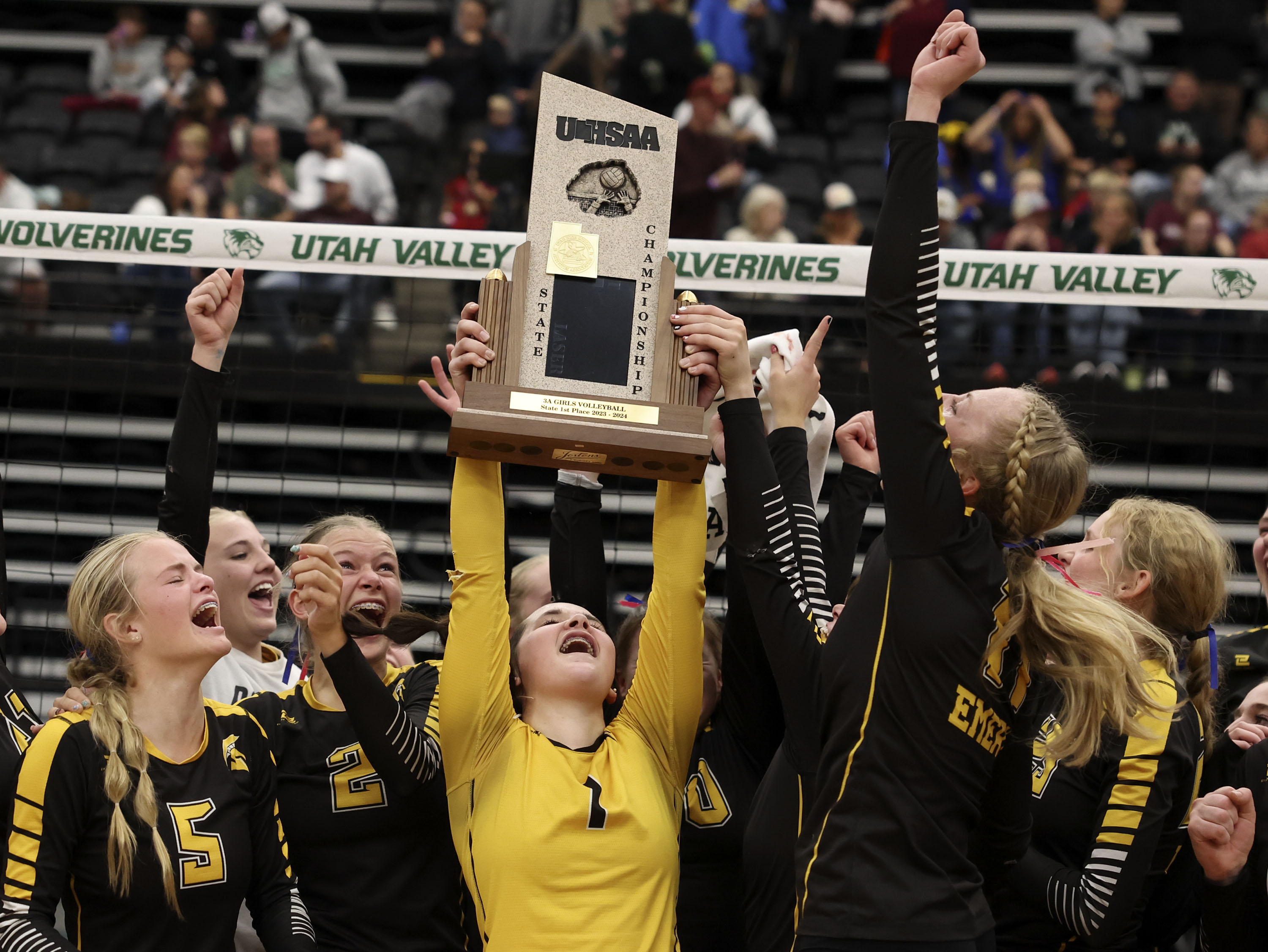 Emery High School celebrates their 3A state volleyball championship win against Morgan High School at Utah Valley University in Orem on Thursday, Oct. 26, 2023.