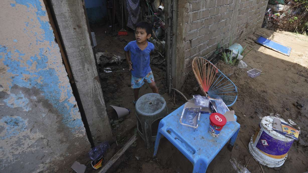 A child stands at the entrance of his damaged home after Hurricane Otis ripped through Acapulco, Mexico, Thursday. The hurricane strengthened swiftly before slamming into the coast early Wednesday as a Category 5 storm.