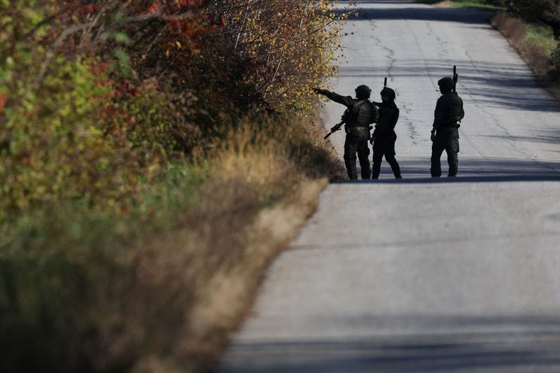 Members of law enforcement work as the search for the suspect in the deadly mass shootings in Lewiston continued, in Monmouth, Maine, Friday.