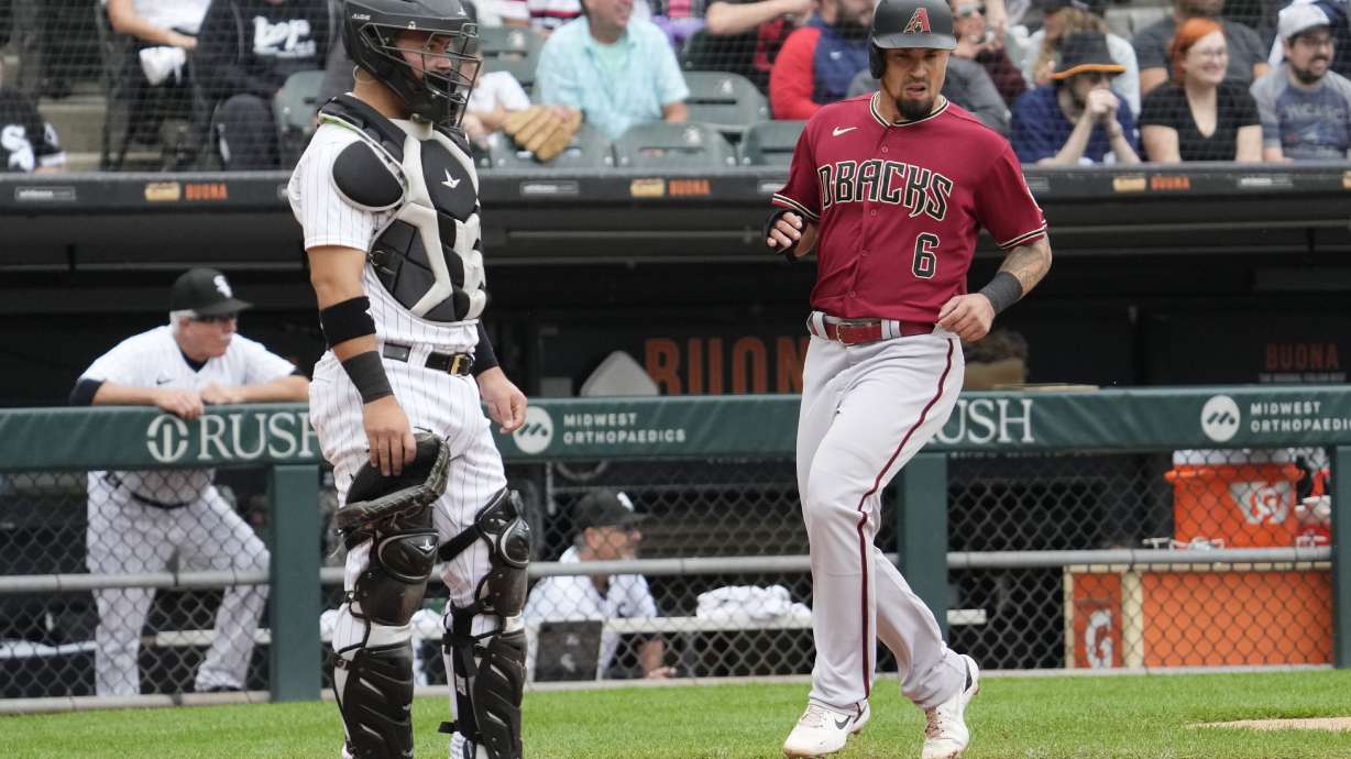 Arizona Diamondbacks' Jace Peterson, right, scores on a two-run double by Corbin Carroll as Chicago White Sox catcher Carlos Perez looks to the field during the third inning of a baseball game in Chicago, Wednesday, Sept. 27, 2023.