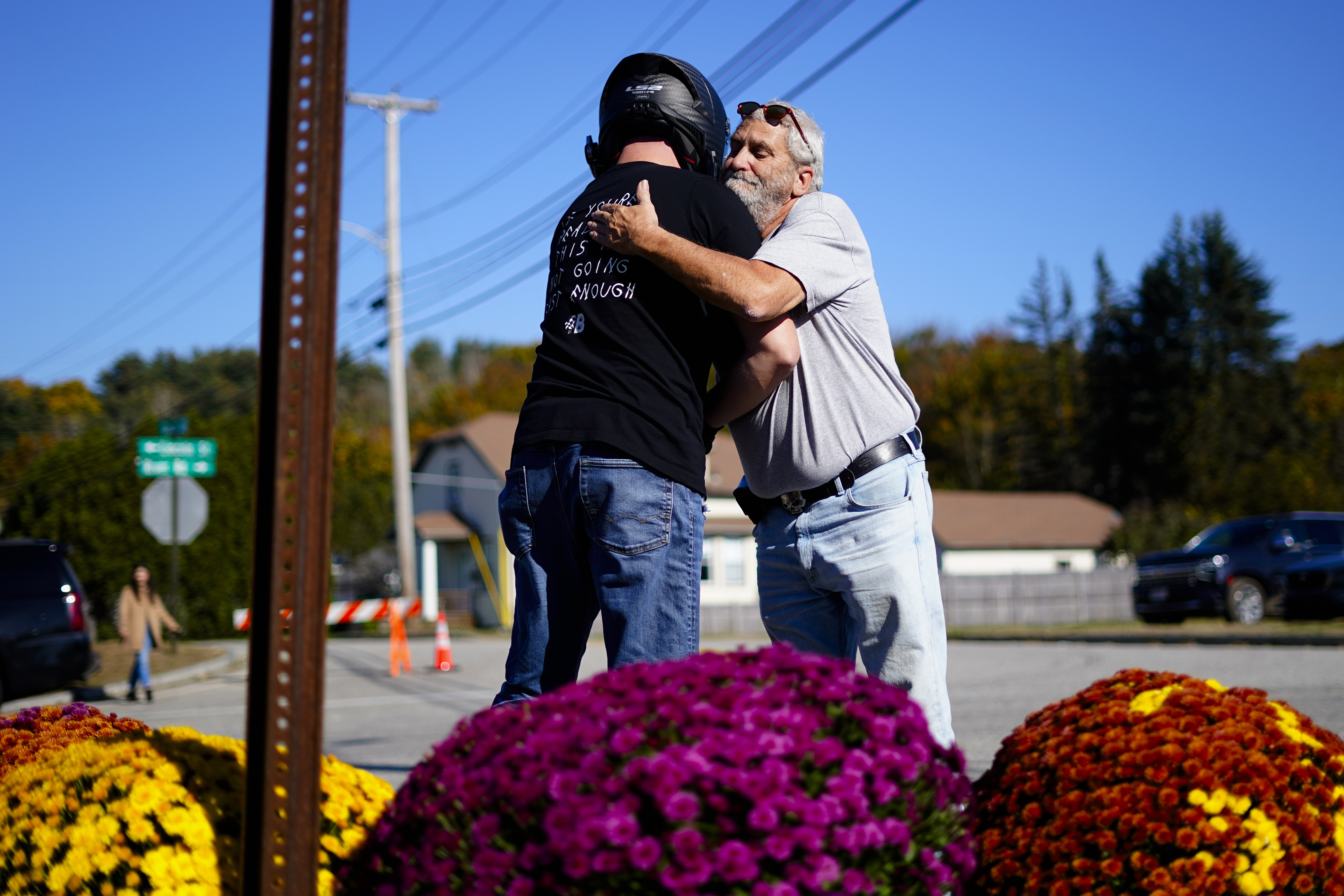 Richard Morlock, right, a member of the deaf community and surviver of the mass shooting at Schemengees Bar and Grille, embraces a person at a makeshift memorial in Lewiston, Maine, Saturday.