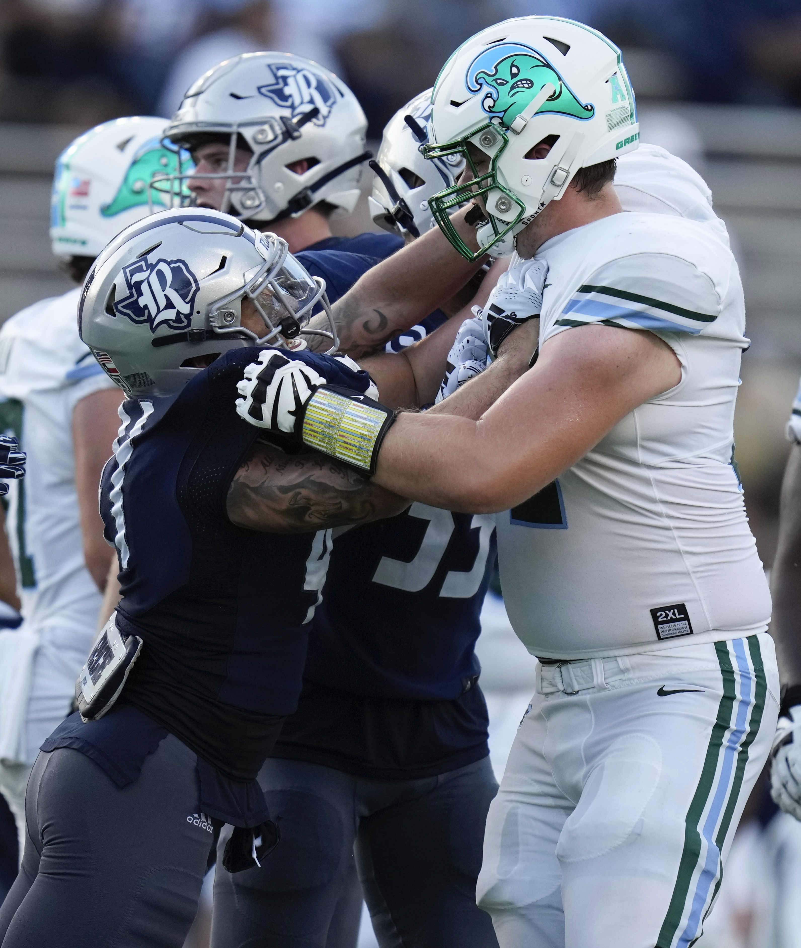 Rice safety Plae Wyatt, left, shoves Tulane offensive lineman Trey Tuggle, right, during the second half of an NCAA college football game, Saturday, Oct. 28, 2023, in Houston.