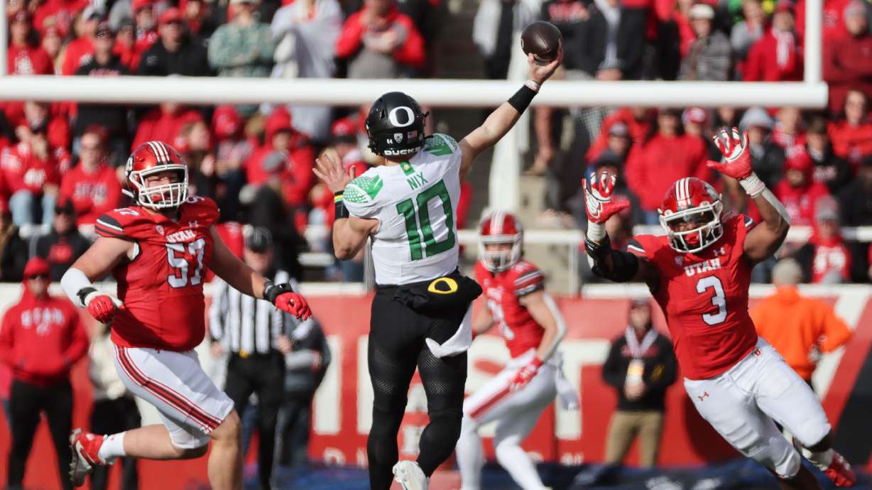 Utah Utes defensive tackle Keanu Tanuvasa (57) and Utah Utes linebacker Levani Damuni (3) hurry Oregon Ducks quarterback Bo Nix (10) in Salt Lake City on Saturday, Oct. 28, 2023. Oregon won 35-6.