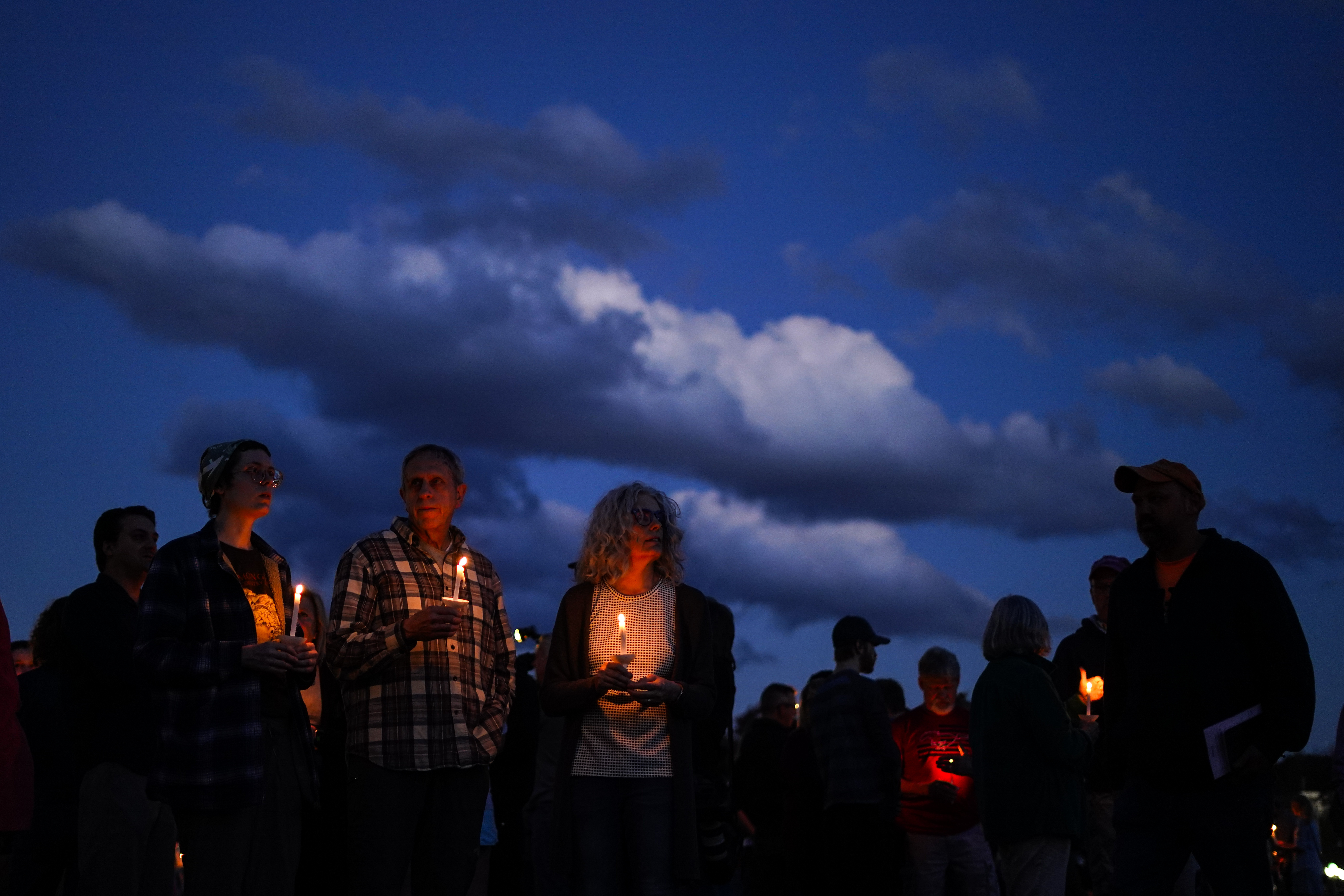 People gather at a vigil in Lisbon Falls, Maine, for victims of the week's mass shootings, Saturday.