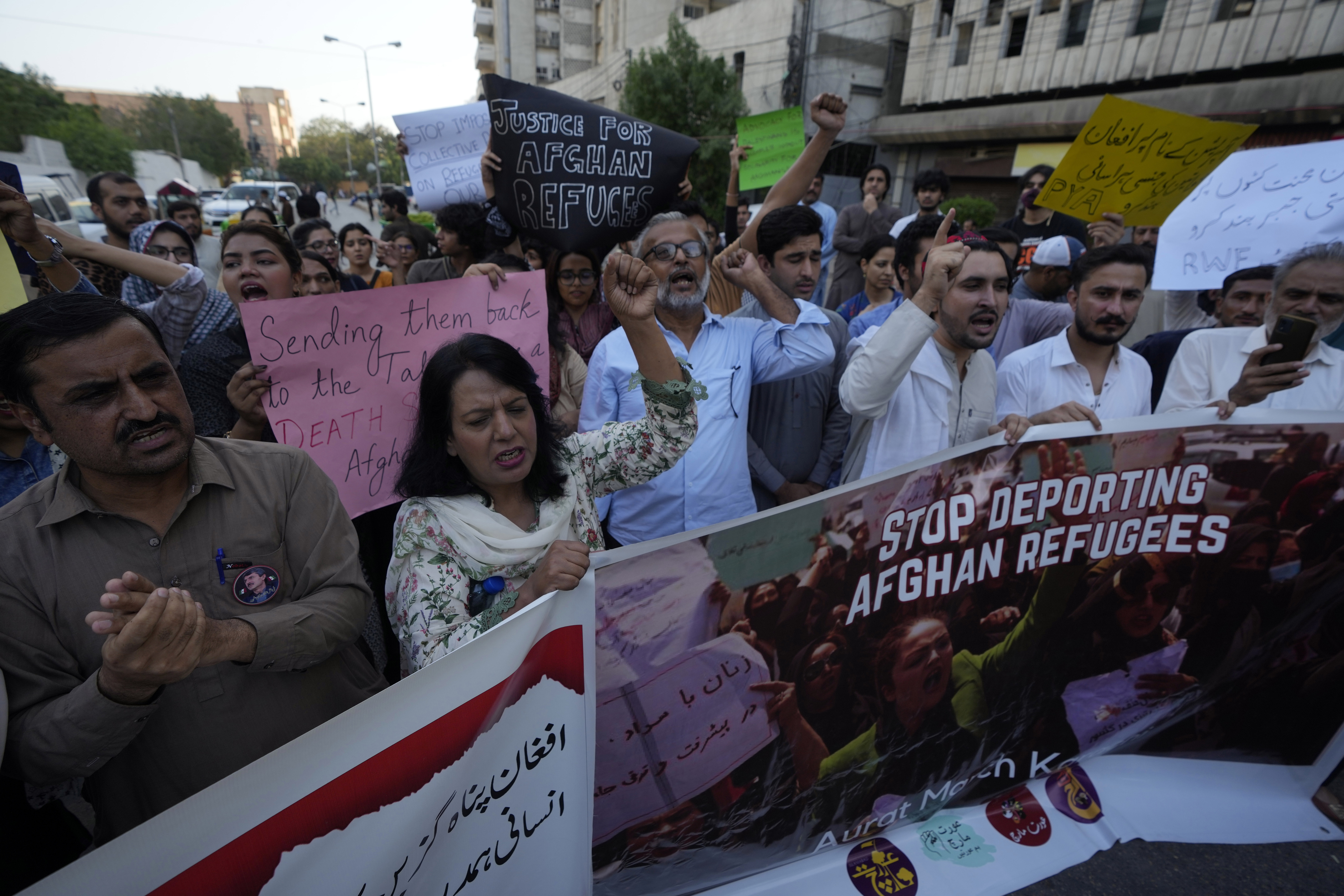 A social group, Aurat March, hold signs during a demonstration against Pakistani government, in Karachi, Pakistan, Sunday. Pakistan says it has recently announced plans to deport all migrants who are in the country illegally, including 1.7 million Afghans, who will be implemented in a "phased and orderly manner."