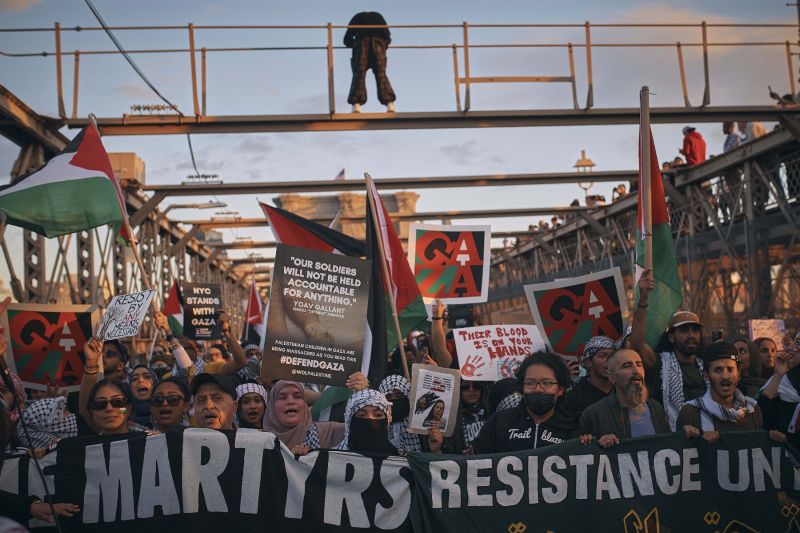 Palestinian supporters shout slogans as they cross the Brooklyn Bridge during a demonstration demanding a cease-fire on Saturday in New York.
