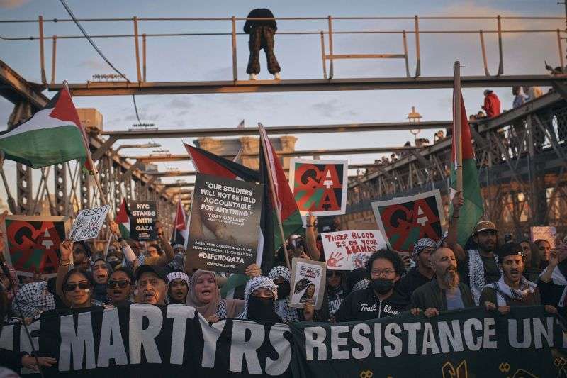 Palestinian supporters shout slogans as they cross the Brooklyn Bridge during a demonstration demanding a cease-fire on Saturday in New York.