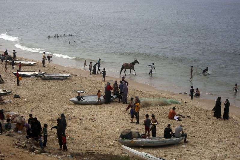 Palestinians resort to the sea water to bathe and clean their tools and clothes due the continuing water shortage in the Gaza Strip, on the beach of Deir al-Balah, Central Gaza Strip, Sunday.