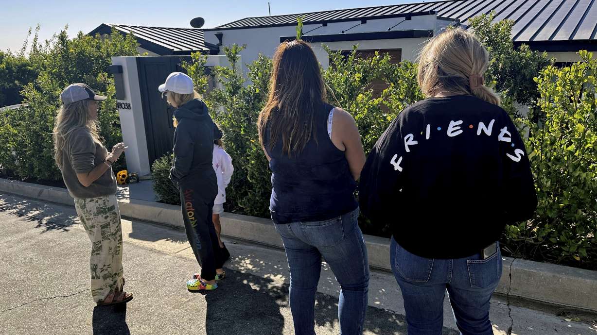Mourners stand outside the home of actor Matthew Perry, Sunday, Oct. 29, 2023, in the Pacific Palisades area of Los Angeles. Perry, who starred as Chandler Bing in the hit series "Friends," has died. He was 54.