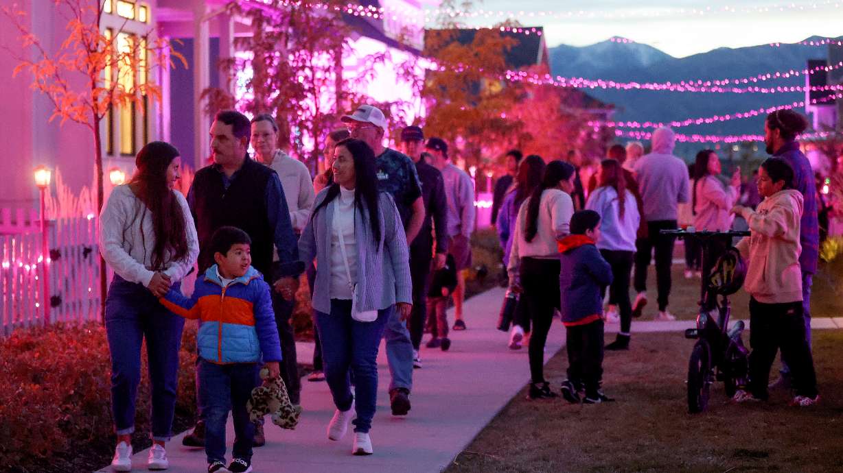 People walk through a Daybreak neighborhood that is decorated in a Barbie theme for Halloween in South Jordan on Oct. 13. Meteorologists say cool but dry conditions are in store for Utah this Halloween.