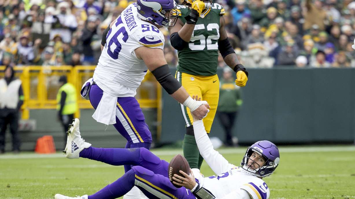 CORRECTS BYLINE TO CARLOS GONZALEZ/STAR TRIBUNE - - Minnesota Vikings quarterback Kirk Cousins (8) is helped up by teammate Garrett Bradbury (56) after a sack in the fourth quarter of an NFL football game against the Green Bay Packers in Miami Gardens, Fla., Sunday, Oct. 29, 2023.
