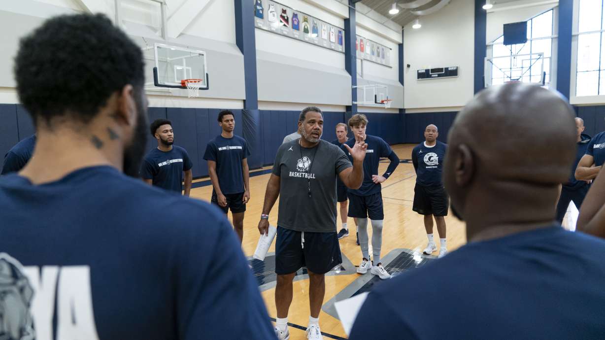 Georgetown head coach Ed Cooley, center, speaks to players before the start of an NCAA college basketball practice Thursday, Oct. 19, 2023, in Washington.
