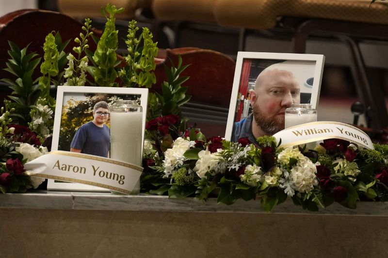 Photos of Aaron Young and his father, William Young, are displayed at a vigil for the victims of Wednesday's mass shootings at the Basilica of Saints Peter and Paul, Sunday in Lewiston, Maine. The Youngs, of Winthrop, Maine, were among those killed in the mass shootings in Lewiston, Maine.