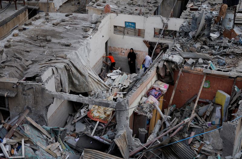 Palestinians check the damage at the site of Israeli strikes on houses, amid the ongoing conflict between Israel and Palestinian Islamist group Hamas, in Khan Younis in the southern Gaza Strip, Sunday.