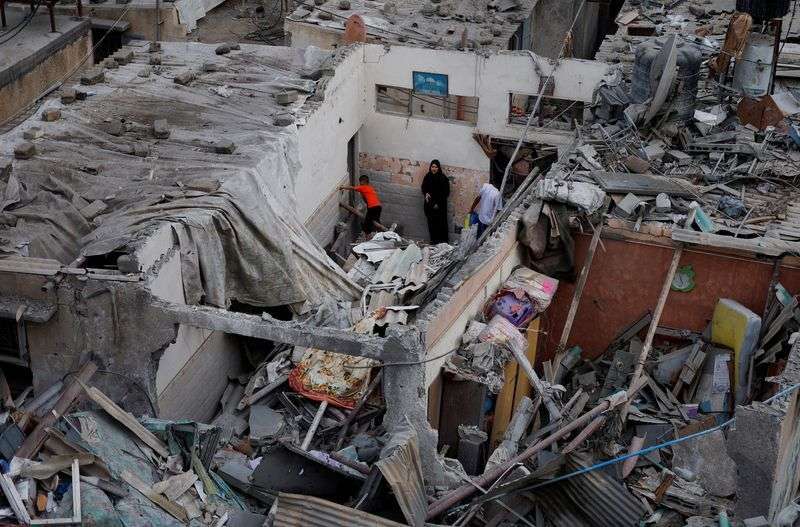 Palestinians check the damage at the site of Israeli strikes on houses, amid the ongoing conflict between Israel and Palestinian Islamist group Hamas, in Khan Younis in the southern Gaza Strip, Sunday.