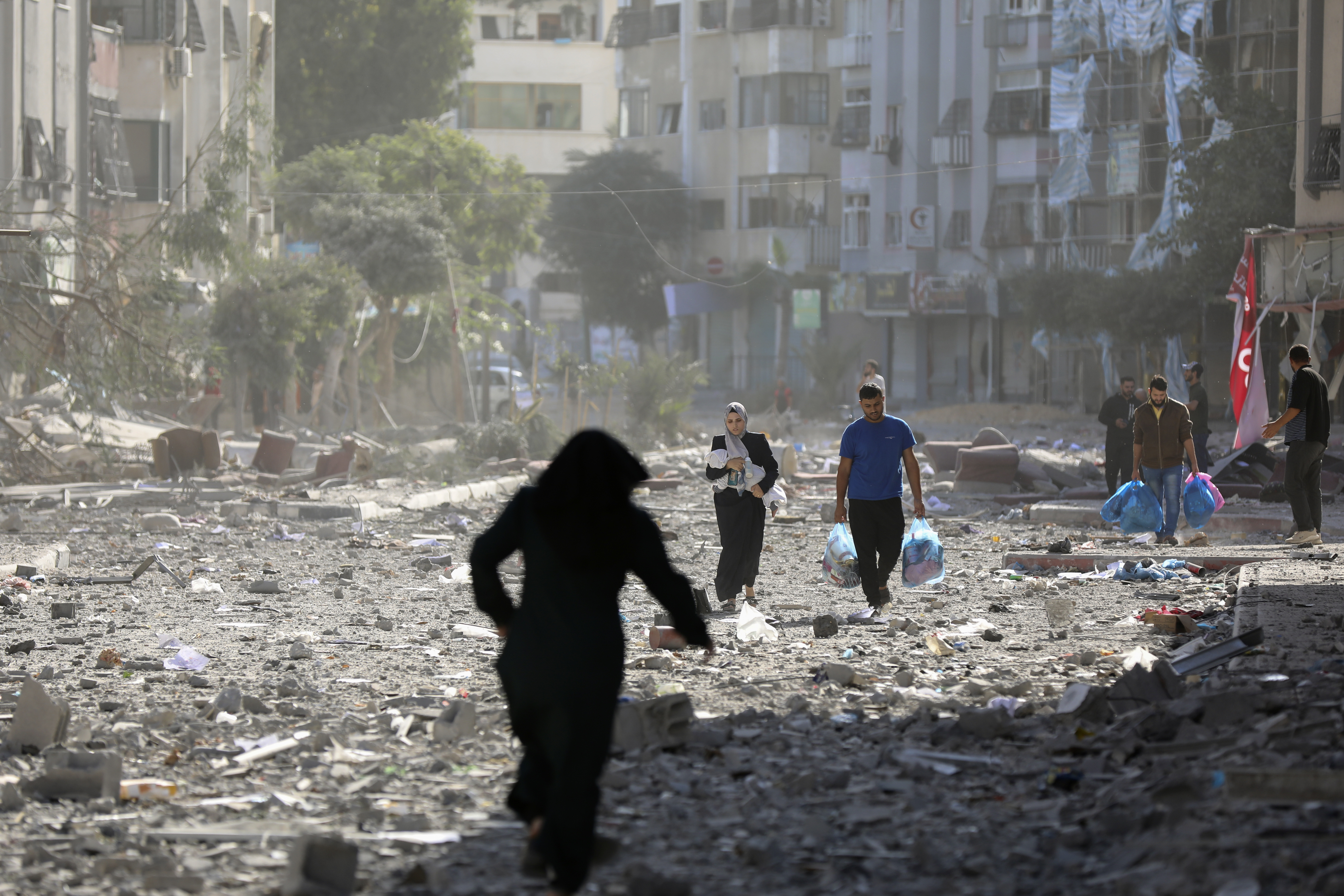 Palestinians leave their homes following Israeli bombardment on Gaza City, Monday.