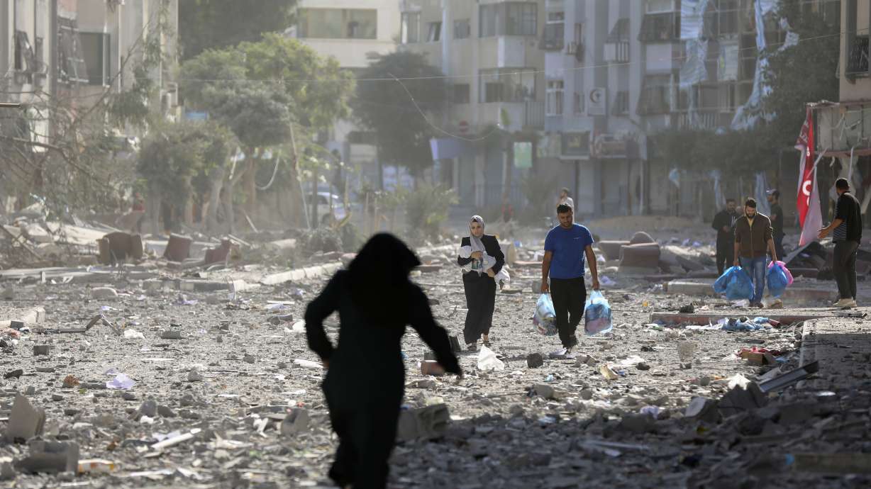 Palestinians leave their homes following Israeli bombardment on Gaza City, Monday.