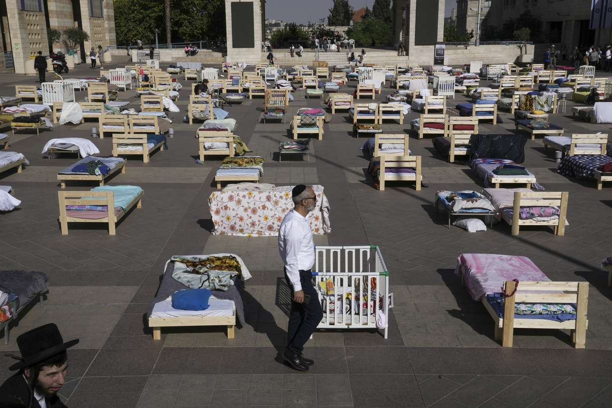 People look at more than 220 beds and items on display symbolizing those captured in a cross-border attack by Hamas militants earlier this month, in Jerusalem, Monday. On Oct. 7, more than 1,400 people, mostly Israeli civilians, were killed and some 240 captured in the unprecedented attack by Hamas, which triggered an ongoing war.