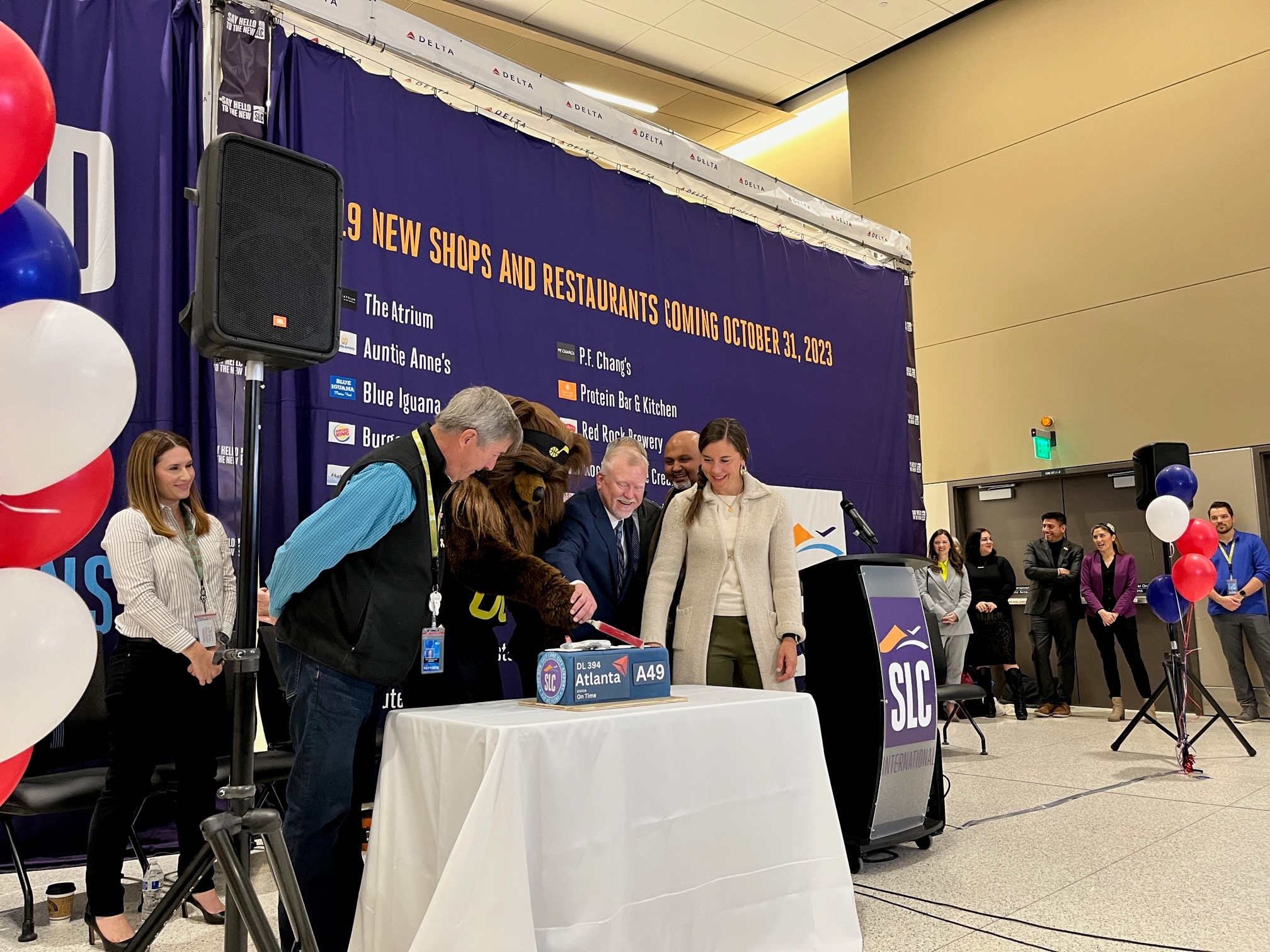 Salt Lake City Mayor Erin Mendenhall, along with Salt Lake City International Airport and Delta Air Lines executives and Utah Jazz's Bear help cut a cake to celebrate the completion of the Concourse A-East project during a ceremony Tuesday.