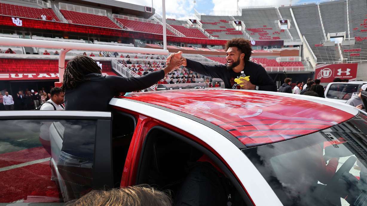 Utah Utes scholarship football players celebrate getting a Dodge truck given to them by the Crimson Collective at Rice-Eccles Stadium in Salt Lake City on Oct. 4. Should such NIL contracts with state schools be public record?