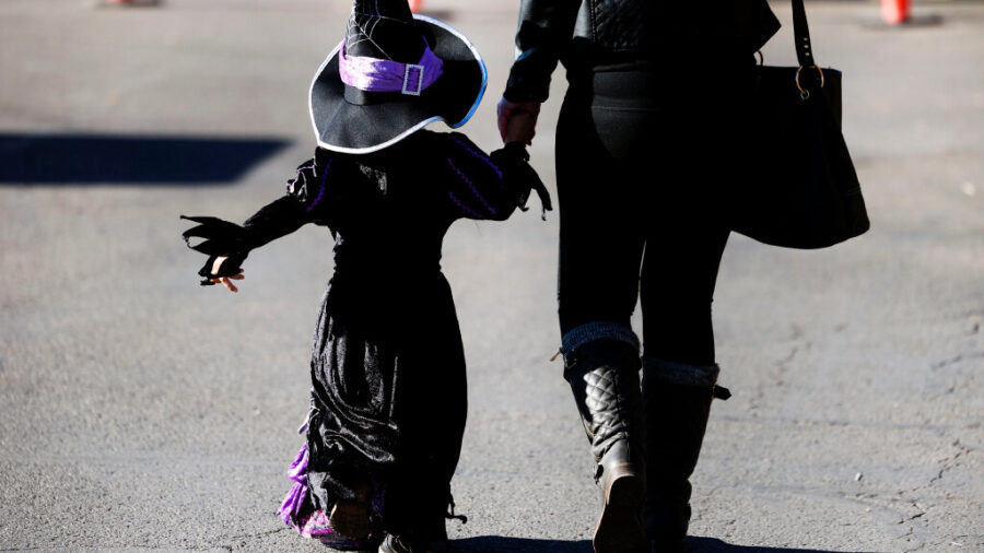 A witch and her guardian at Gardner Village in West Jordan on Friday. Halloween is the second-busiest night of the year for police. The majority of calls will be drug and alcohol related, according to police.
