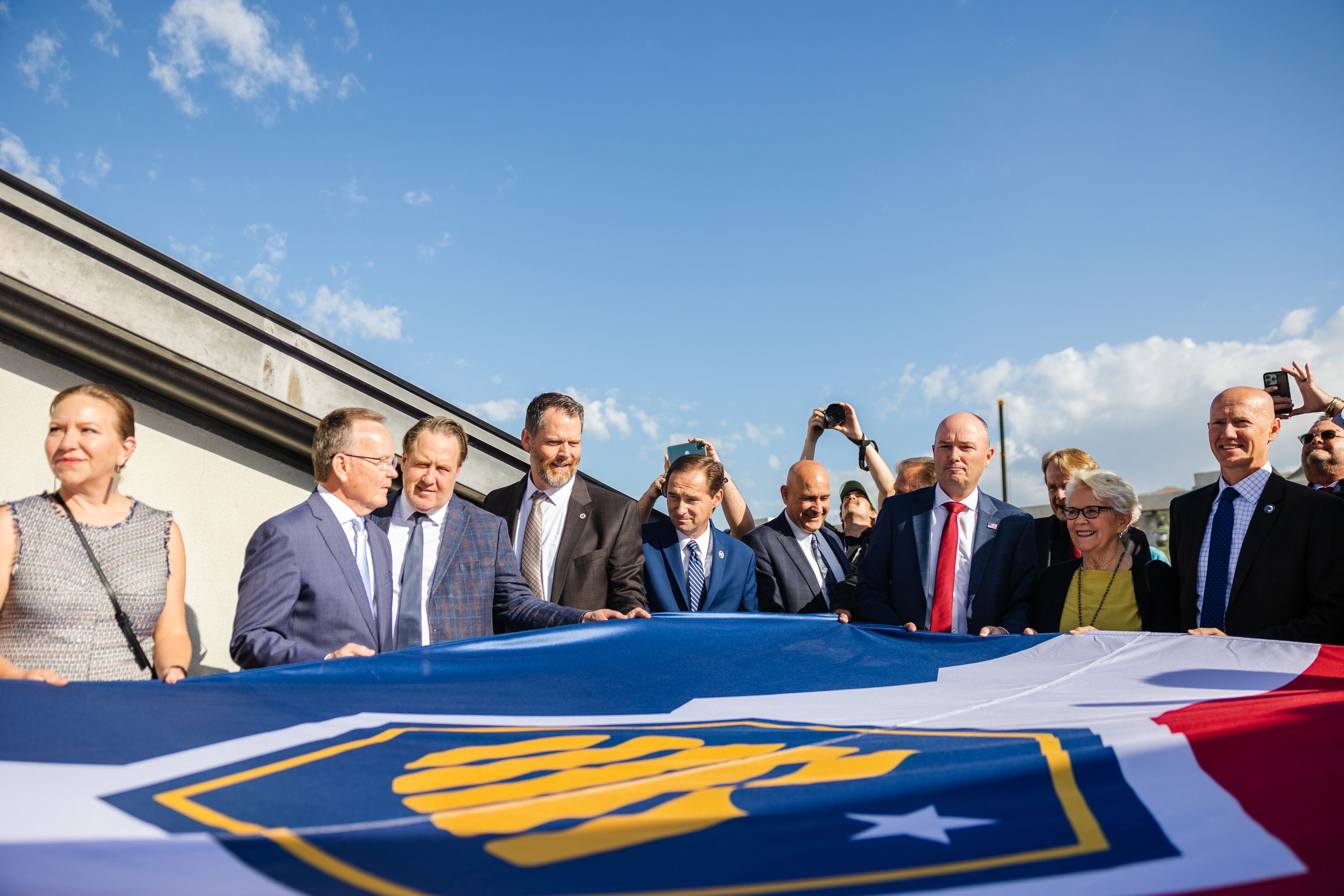 Utah State officials including Utah Gov. Spencer Cox and Senate President Stuart Adams, R-Layton, hold the flag during the raising of the new Utah state flag at the Capitol in Salt Lake City on May 17.