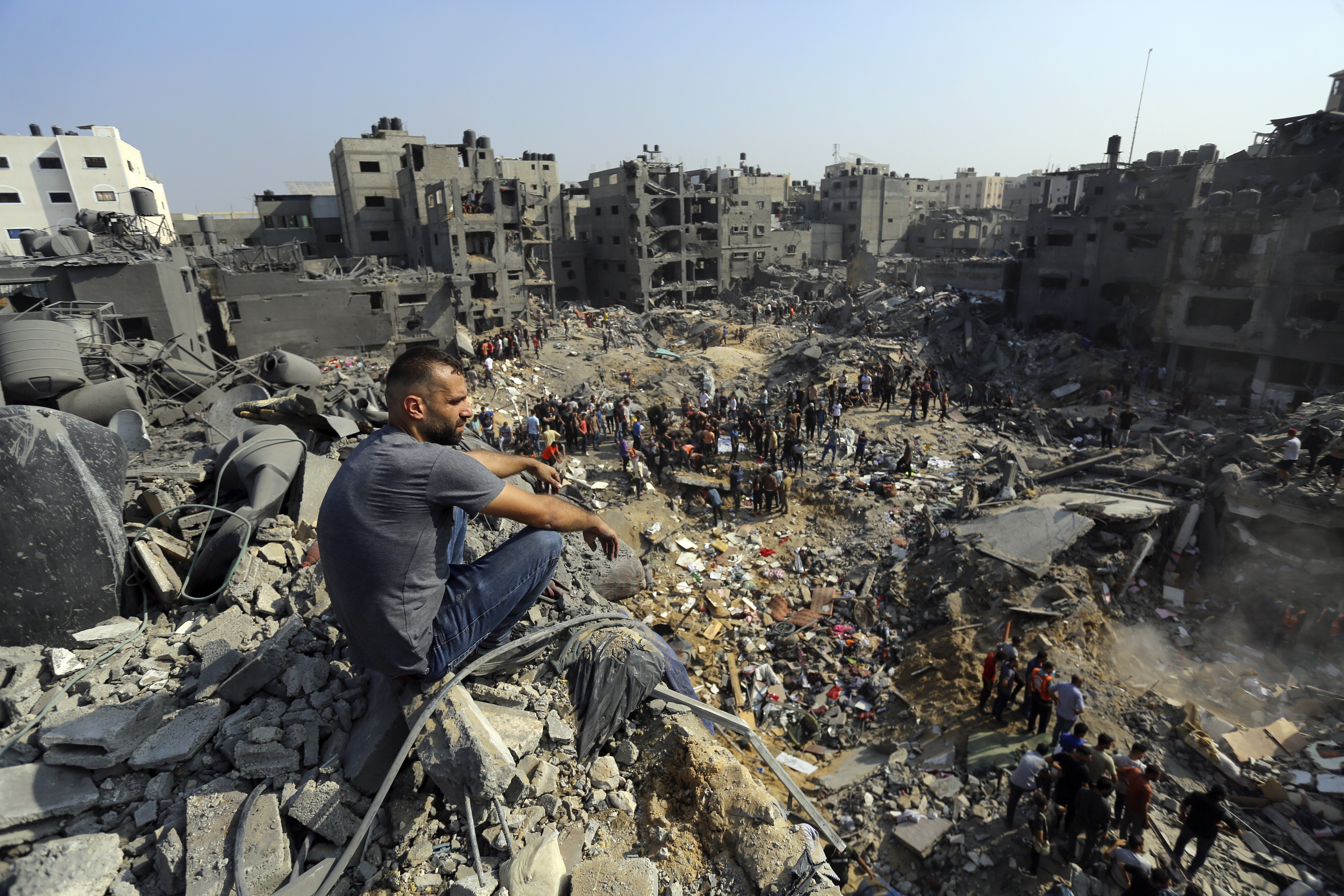 A man sits on the rubble of buildings that were targeted by Israeli airstrikes in Jabaliya refugee camp, northern Gaza Strip, Wednesday. Israeli troops have encircled Gaza in heavy fighting with Hamas militants, the military says.