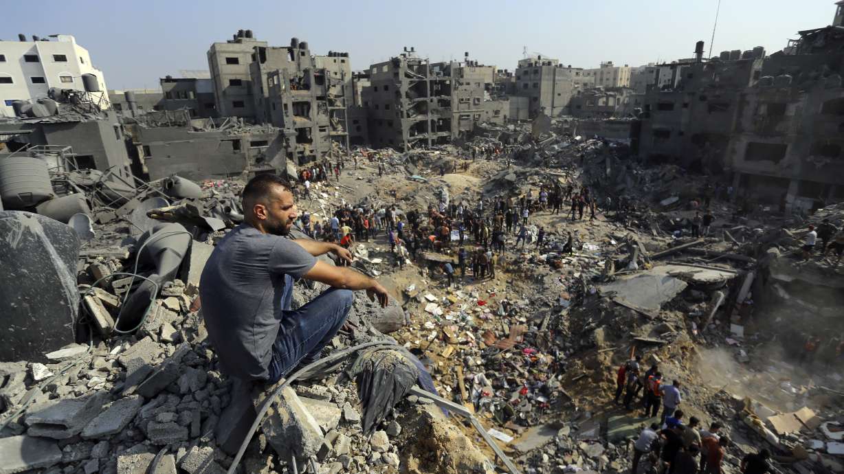 A man sits on the rubble of buildings that were targeted by Israeli airstrikes in Jabaliya refugee camp, northern Gaza Strip, Wednesday. Israeli troops have encircled Gaza in heavy fighting with Hamas militants, the military says.