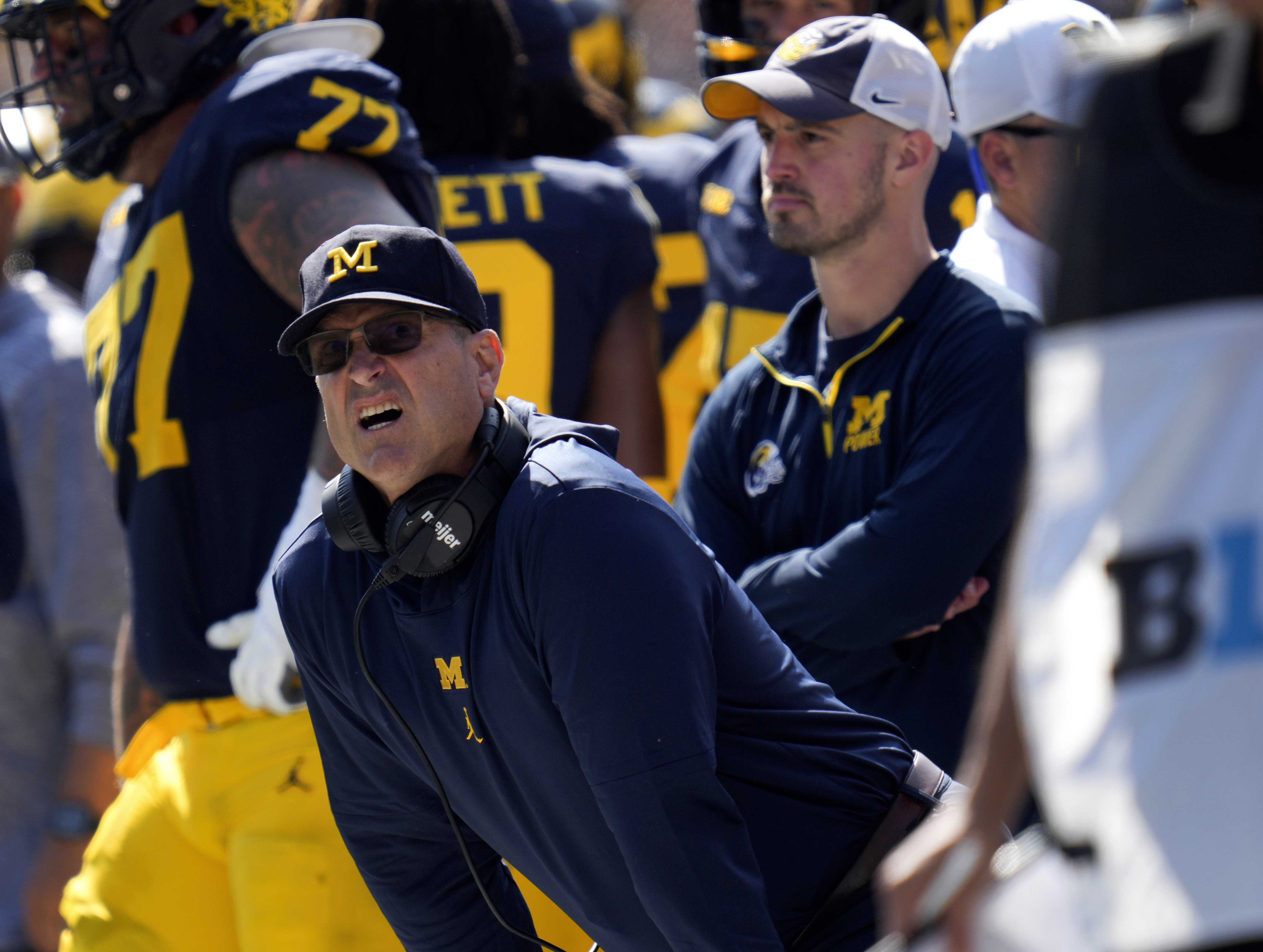 Michigan head coach Jim Harbaugh, front left, watches against Rutgers as analytics assistant Connor Stalions, right, looks on during an NCAA college football game in Ann Arbor, Mich., Sept. 23, 2023. Stalions was suspended by the university last week and is at the center of a sign-stealing scheme that is being investigated by the NCAA. 