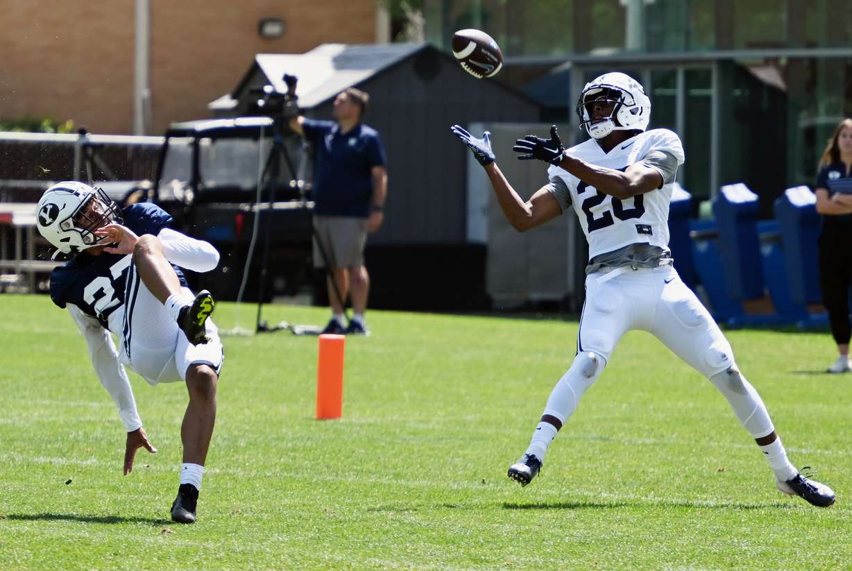 BYU wide receiver Jojo Phillips brings in a long pass for a touchdown as cornerback Marcus McKenzie falls down during BYU practice in Provo on Tuesday, Aug. 8, 2023.