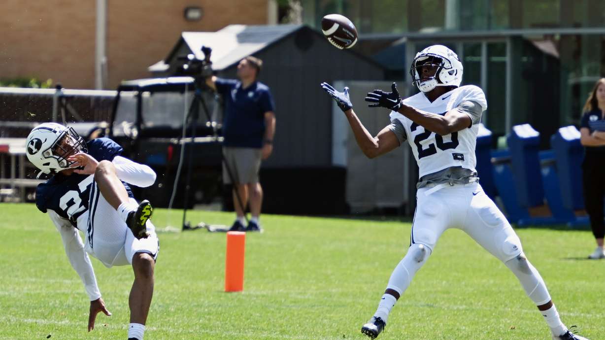 BYU wide receiver Jojo Phillips brings in a long pass for a touchdown as cornerback Marcus McKenzie falls down during BYU practice in Provo on Tuesday, Aug. 8, 2023.