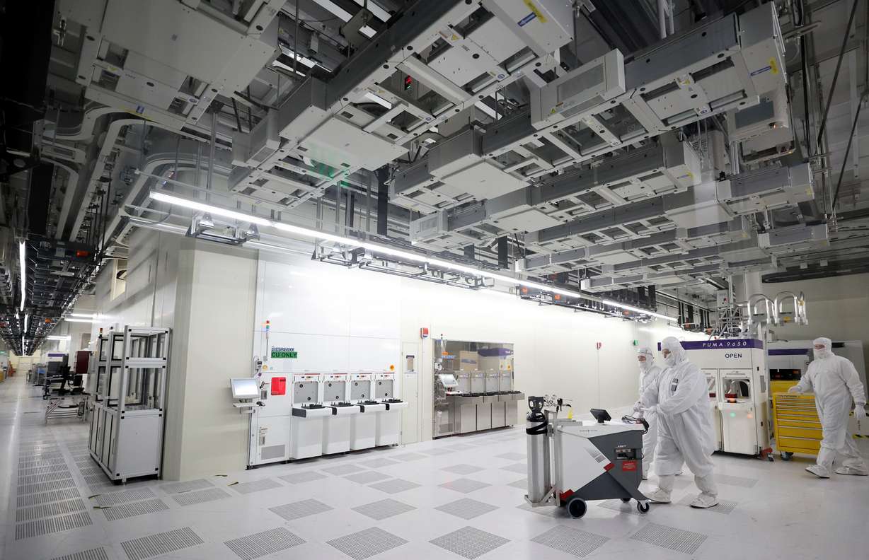 Manufacturing technicians work in a cleanroom, supporting semiconductor wafer fabrication, at Texas Instruments in Lehi on Thursday.
