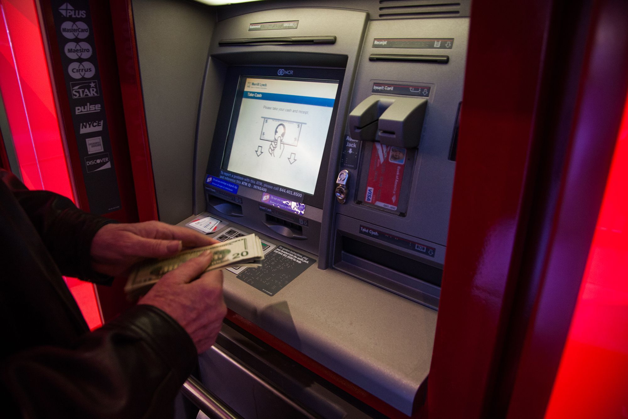 A customer withdraws money from an automatic teller machine inside a Bank of America Corp. branch in New York, in 2018. An error at a payment processing network caused deposit delays at multiple U.S. banks.